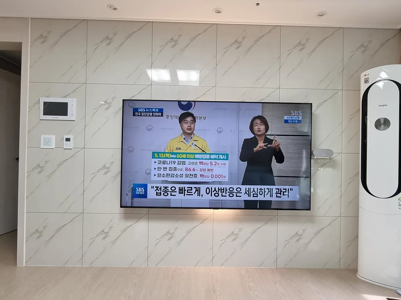 부천벽걸이티비설치 현장 - 부천 아파트 (설치 후). 인터폰과 컨트롤러를 피해 타일 벽에 브라켓으로 고정하고 선까지 정리했습니다.