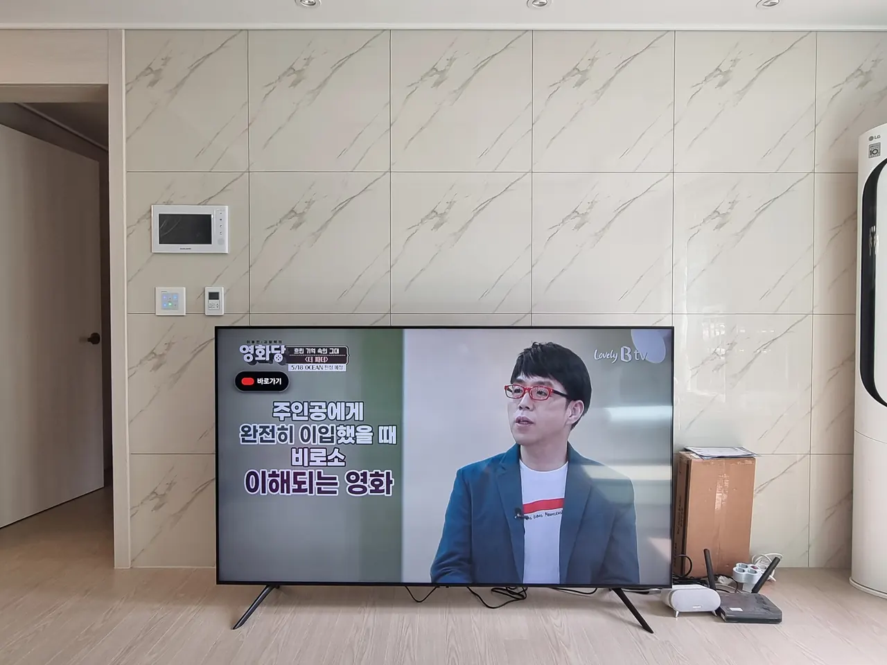 부천벽걸이티비설치 현장 - 부천 아파트 (설치 전). 새로 산 TV가 거실 바닥 스탠드에 세워져 있던 상태입니다.
