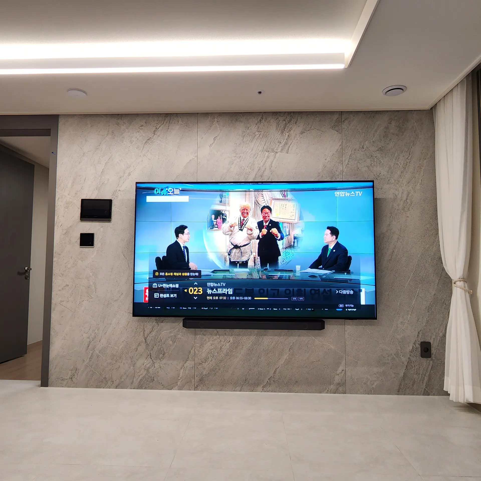 벽걸이티비설치 완료 사진 - 대리석 아트월 거실에 TV와 사운드바를 함께 설치한 모습