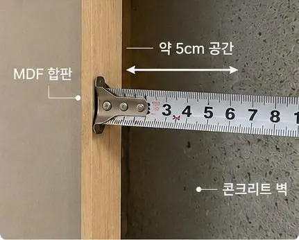 벽걸이티비설치 시공 사례 - 벽 구조 확인. 타공 전 확인구로 MDF 합판과 콘크리트 벽 사이 공간을 재는 모습입니다.